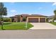 Beautiful single-story home with a well-manicured lawn and a three-car garage on a sunny day at 1275 Blue Lake Cir, Punta Gorda, FL 33983
