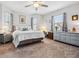 Bright main bedroom features a ceiling fan, plush carpet, and a large dresser at 1275 Blue Lake Cir, Punta Gorda, FL 33983