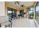 A covered outdoor patio with tile flooring, comfortable seating, ceiling fans, and a view of the yard at 1275 Blue Lake Cir, Punta Gorda, FL 33983