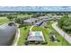 Community aerial view featuring a pool, nearby lake, and multiple condos with manicured lawns at 1375 Saxony Cir # 124, Punta Gorda, FL 33983