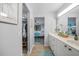 Bright bathroom featuring white cabinetry, a closet, and a glimpse into the bedroom at 1375 Saxony Cir # 124, Punta Gorda, FL 33983