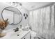Well-lit bathroom features a stylish round mirror, attractive vanity, and tiled shower at 1375 Saxony Cir # 124, Punta Gorda, FL 33983