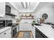 Updated kitchen with stainless steel appliances, white cabinetry and stylish open shelving at 1375 Saxony Cir # 124, Punta Gorda, FL 33983