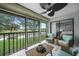 Relaxing screened-in lanai with wicker furniture offering scenic views of the golf course and lake at 1375 Saxony Cir # 124, Punta Gorda, FL 33983