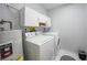 Functional laundry room equipped with a washer, dryer, and overhead cabinetry for storage at 1375 Saxony Cir # 124, Punta Gorda, FL 33983