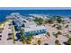Aerial view showcasing a marina with boat parking, a blue building with palms, and parking spaces at 1375 Saxony Cir # 124, Punta Gorda, FL 33983