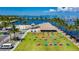 Aerial view of vibrant outdoor seating area with a beach, parking, and waterway featuring tiki style huts at 1375 Saxony Cir # 124, Punta Gorda, FL 33983