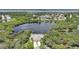 Aerial view of a home surrounded by lush landscaping, with a lake in the backyard at 14311 Reserve Ct, Port Charlotte, FL 33953