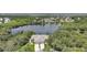 Aerial view of a home featuring a tile roof, three-car garage, mature trees and landscaping at 14311 Reserve Ct, Port Charlotte, FL 33953