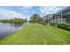 Green lawn sloping gently to a lake, adjacent to the screened-in patio at 14311 Reserve Ct, Port Charlotte, FL 33953