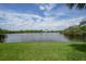 Well-maintained lawn leading to a serene lake with lush vegetation at 14311 Reserve Ct, Port Charlotte, FL 33953
