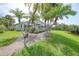 Backyard of home with a screened-in lanai and lush tropical landscaping at 14311 Reserve Ct, Port Charlotte, FL 33953