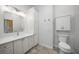 Bright bathroom with a white vanity, built-in cabinet, toilet, and neutral tile flooring at 14311 Reserve Ct, Port Charlotte, FL 33953
