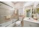 Bathroom featuring a tub with sliding doors, a white toilet, and vanity with neutral wallpaper at 14311 Reserve Ct, Port Charlotte, FL 33953