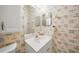 Small bathroom with seashell-themed wallpaper and a white vanity with a mirror at 14311 Reserve Ct, Port Charlotte, FL 33953