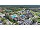An aerial shot reveals a community pool, clubhouse, and sports courts amidst lush greenery and parking at 14311 Reserve Ct, Port Charlotte, FL 33953