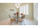 Cozy dining area with a glass-top table, chandelier, and views of the garden at 14311 Reserve Ct, Port Charlotte, FL 33953