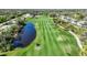 An expansive golf course is showcased with lush fairways, a serene pond, and surrounding natural beauty at 14311 Reserve Ct, Port Charlotte, FL 33953