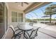 Outdoor lanai features a dining table, patio furniture, and a serene view of the pool and lake at 14311 Reserve Ct, Port Charlotte, FL 33953