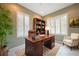 Well-lit office featuring a classic wooden desk, bookcase, and plantation shutters at 14311 Reserve Ct, Port Charlotte, FL 33953