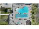 Aerial view of a community pool with a unique shape, surrounded by lounge chairs and tables at 14311 Reserve Ct, Port Charlotte, FL 33953