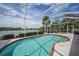 Inviting pool area with access to a screened-in lanai and tranquil water views at 14311 Reserve Ct, Port Charlotte, FL 33953