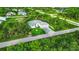 Aerial shot of a modern home featuring a well-manicured lawn and a paved driveway in a green neighborhood at 14520 Edna Cir, Port Charlotte, FL 33981