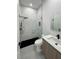 A bright bathroom with a tiled shower, glass enclosure, and wood vanity at 14520 Edna Cir, Port Charlotte, FL 33981