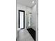 Sleek bathroom with black-framed glass shower, toilet, and gray tile flooring at 14520 Edna Cir, Port Charlotte, FL 33981