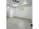 Spacious bedroom with light gray tile flooring, a modern fan and a window at 14520 Edna Cir, Port Charlotte, FL 33981