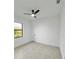 A bright and airy bedroom featuring a ceiling fan and large window with natural light at 14520 Edna Cir, Port Charlotte, FL 33981
