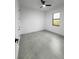 This bedroom features gray tile flooring, a ceiling fan, and a window with natural light at 14520 Edna Cir, Port Charlotte, FL 33981