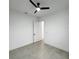 Minimalist bedroom with a ceiling fan, gray tile flooring, and white walls at 14520 Edna Cir, Port Charlotte, FL 33981