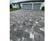 Paver driveway leading to a modern home with a two-car garage, complemented by manicured landscaping at 14520 Edna Cir, Port Charlotte, FL 33981