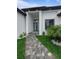 Eye-level view of a modern home's entrance with a paved walkway and manicured landscaping features at 14520 Edna Cir, Port Charlotte, FL 33981