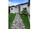 Stylish front entrance of a modern home with a paved walkway and well-maintained green spaces at 14520 Edna Cir, Port Charlotte, FL 33981