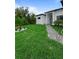 Green front yard and brick walkway leading to the home's entrance, bordered by landscaping features at 14520 Edna Cir, Port Charlotte, FL 33981