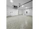 Three car garage with white walls and epoxy flooring, offering a clean and functional space with entry door at 14520 Edna Cir, Port Charlotte, FL 33981