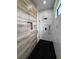 Luxurious shower featuring marble and wood-style tile accents with a sleek, black shower system and a glass enclosure at 14520 Edna Cir, Port Charlotte, FL 33981
