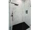 Modern shower with frameless glass door, black hardware, and marble tile at 14520 Edna Cir, Port Charlotte, FL 33981