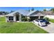 Attractive single-story home featuring a metal roof, manicured landscaping, and a three-car garage at 15117 Lyneburg Ave, Port Charlotte, FL 33981
