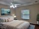 Staged main bedroom featuring a tray ceiling, cozy decor, and a window for natural light at 15117 Lyneburg Ave, Port Charlotte, FL 33981