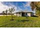 Exterior view of home with a large, green backyard at 16403 Perdida Ct, Punta Gorda, FL 33955