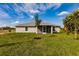 View of the home's backyard featuring a manicured lawn and young trees at 16403 Perdida Ct, Punta Gorda, FL 33955