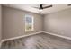 This bedroom features gray walls, wood-look flooring, and a ceiling fan at 16403 Perdida Ct, Punta Gorda, FL 33955