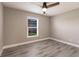 Bedroom featuring gray walls, modern ceiling fan, window with blinds, and wood-look flooring at 16403 Perdida Ct, Punta Gorda, FL 33955