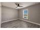 Bedroom featuring gray walls, wood-look flooring, modern ceiling fan, and window with blinds at 16403 Perdida Ct, Punta Gorda, FL 33955