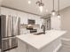 Modern kitchen features stainless steel appliances, white cabinetry, island, and stylish pendant lighting at 16403 Perdida Ct, Punta Gorda, FL 33955
