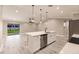 Contemporary kitchen features an island with breakfast bar and sliding doors to outdoor patio at 16403 Perdida Ct, Punta Gorda, FL 33955