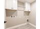 Practical laundry room featuring white cabinets, gray walls and wood-look flooring at 16403 Perdida Ct, Punta Gorda, FL 33955